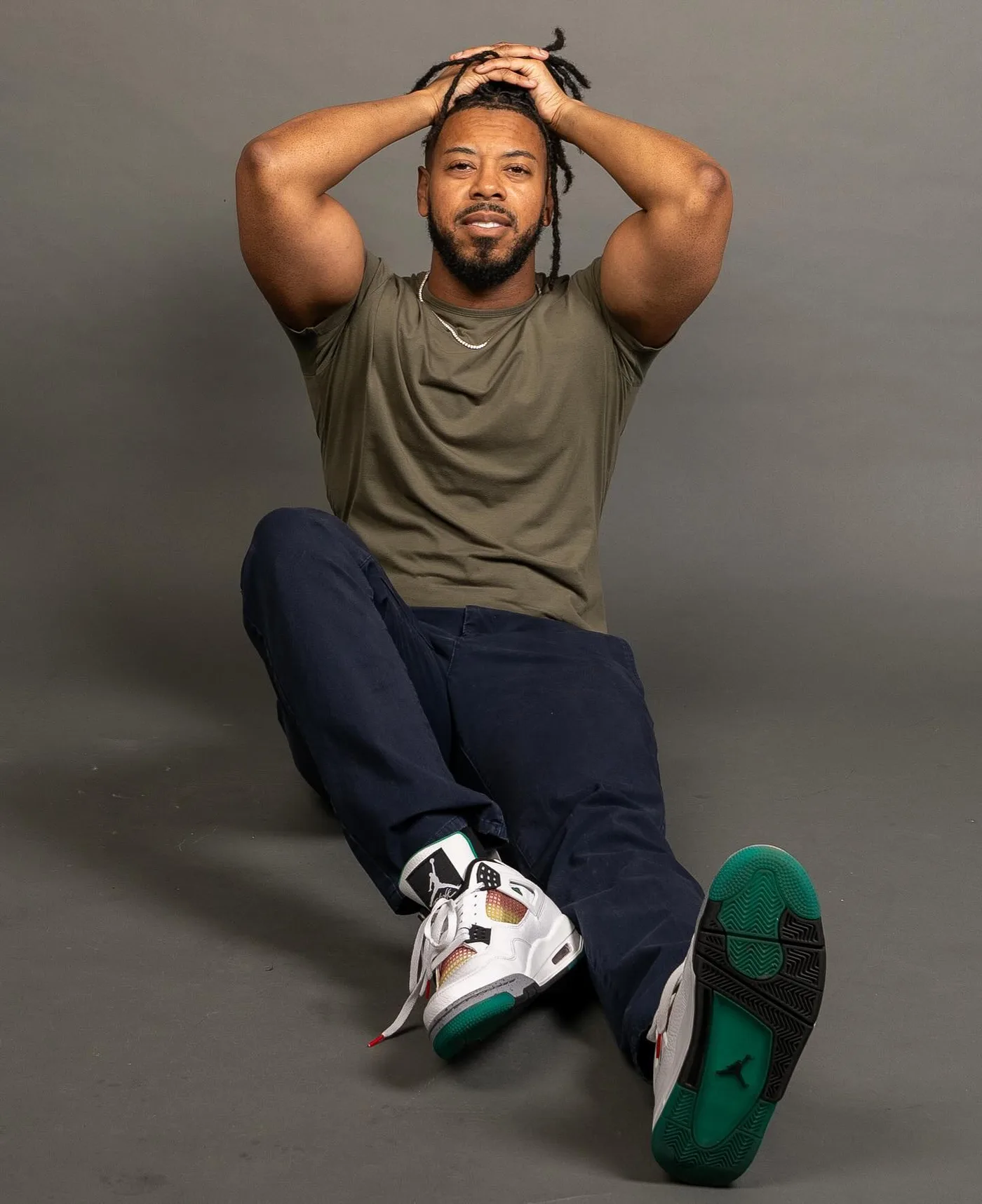 William seated in an olive shirt for a catalog-style portrait