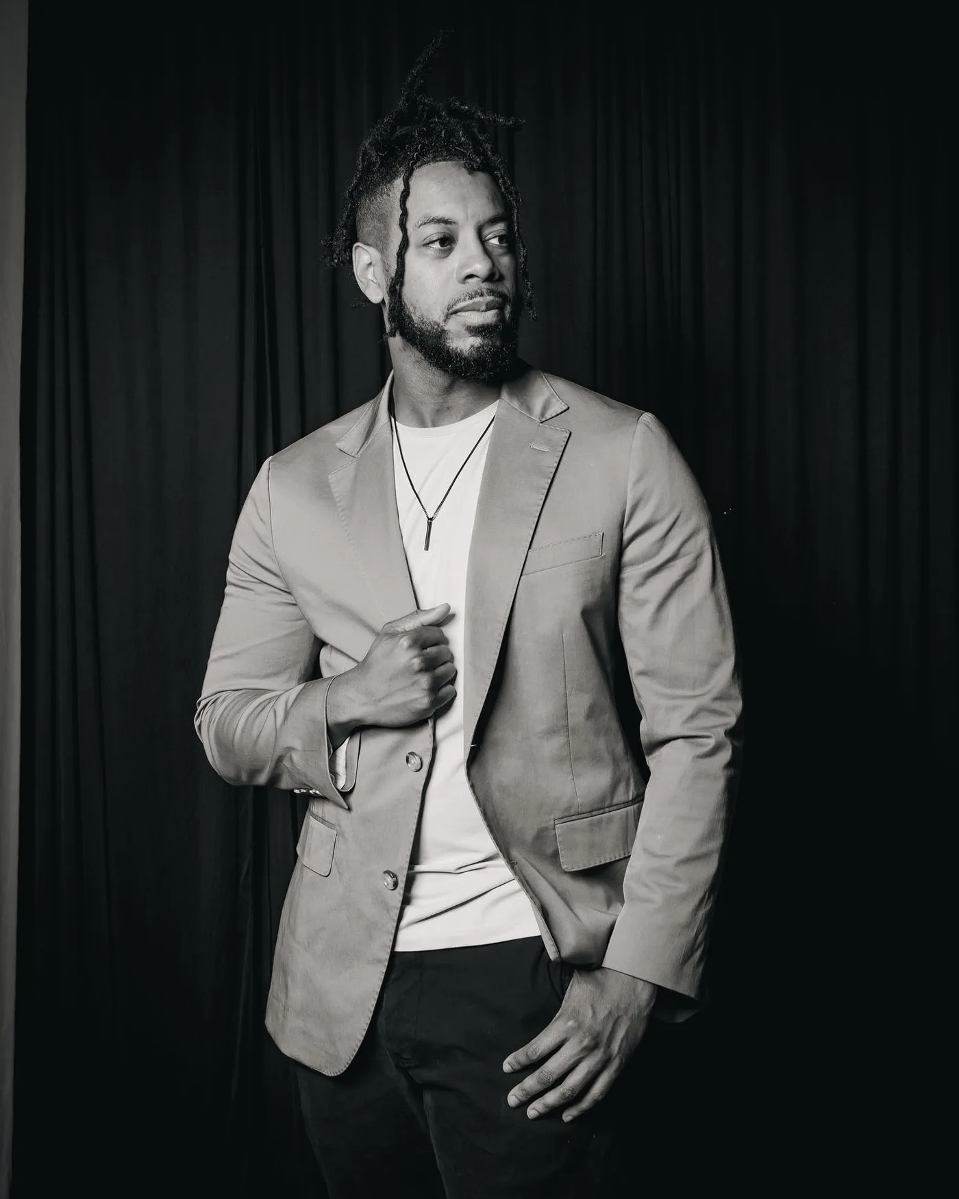 Black-and-white editorial portrait of William in a tan blazer