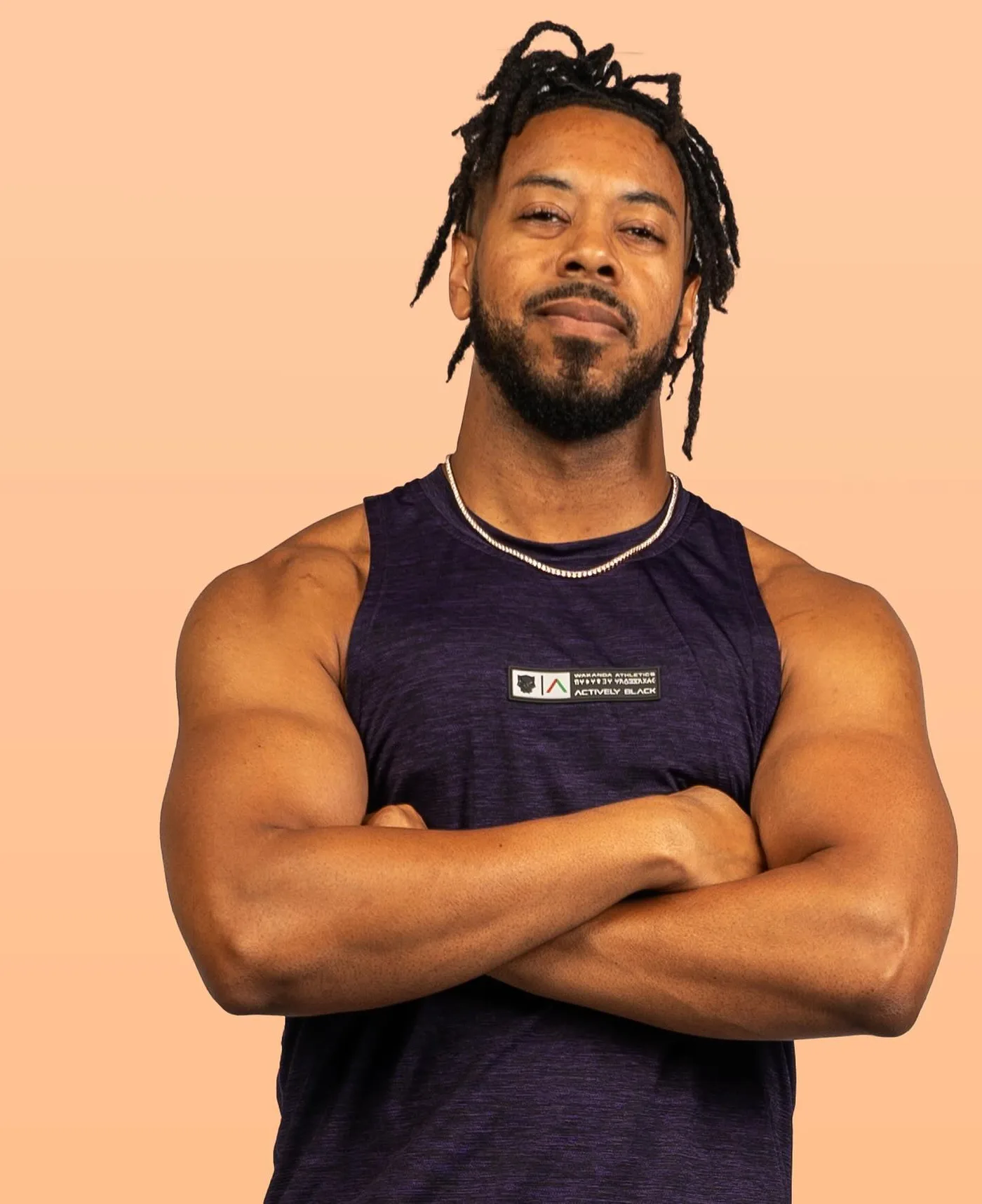 William in an athletic tank against a peach backdrop
