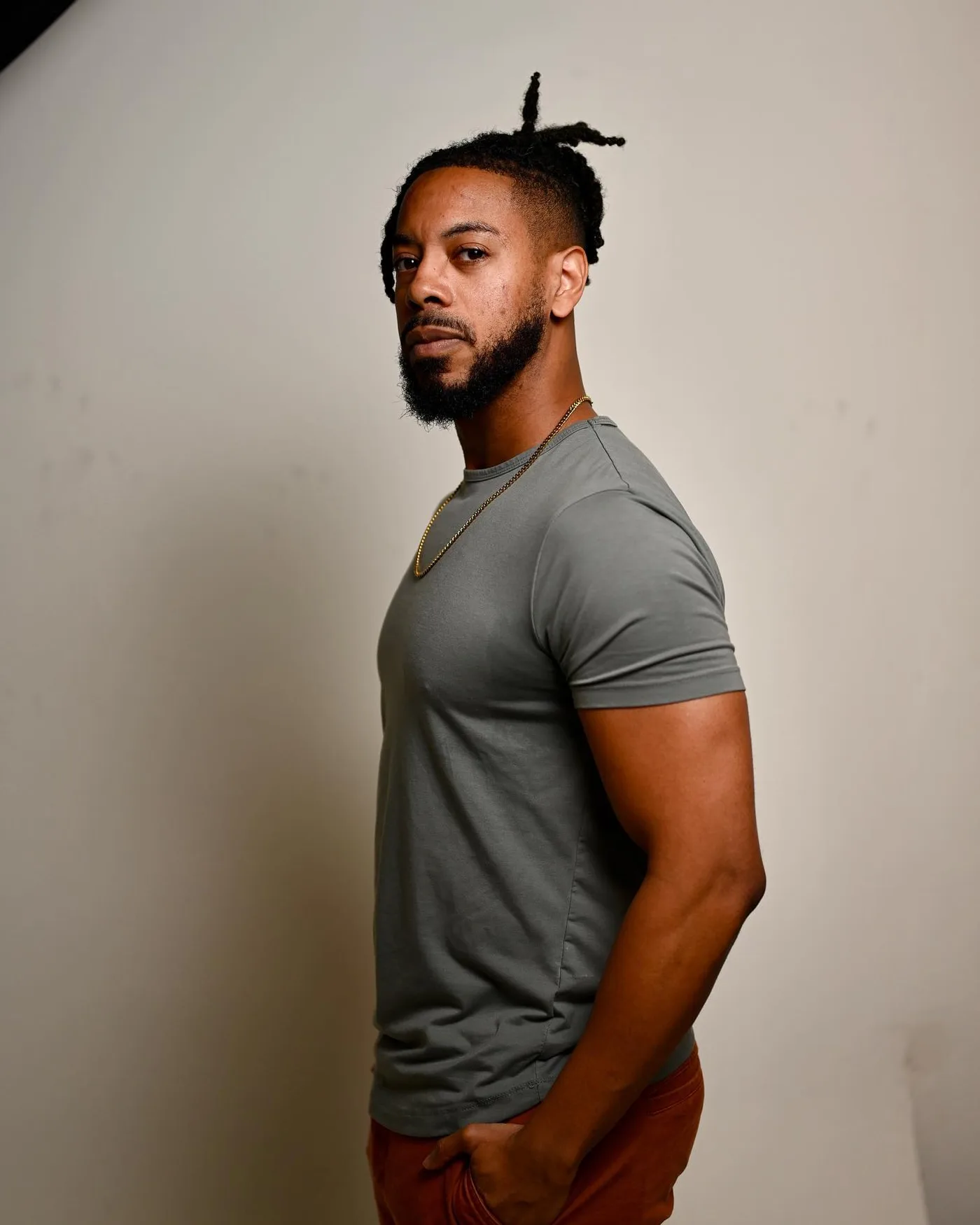 Full-length catalog image of William in a grey T-shirt and rust trousers