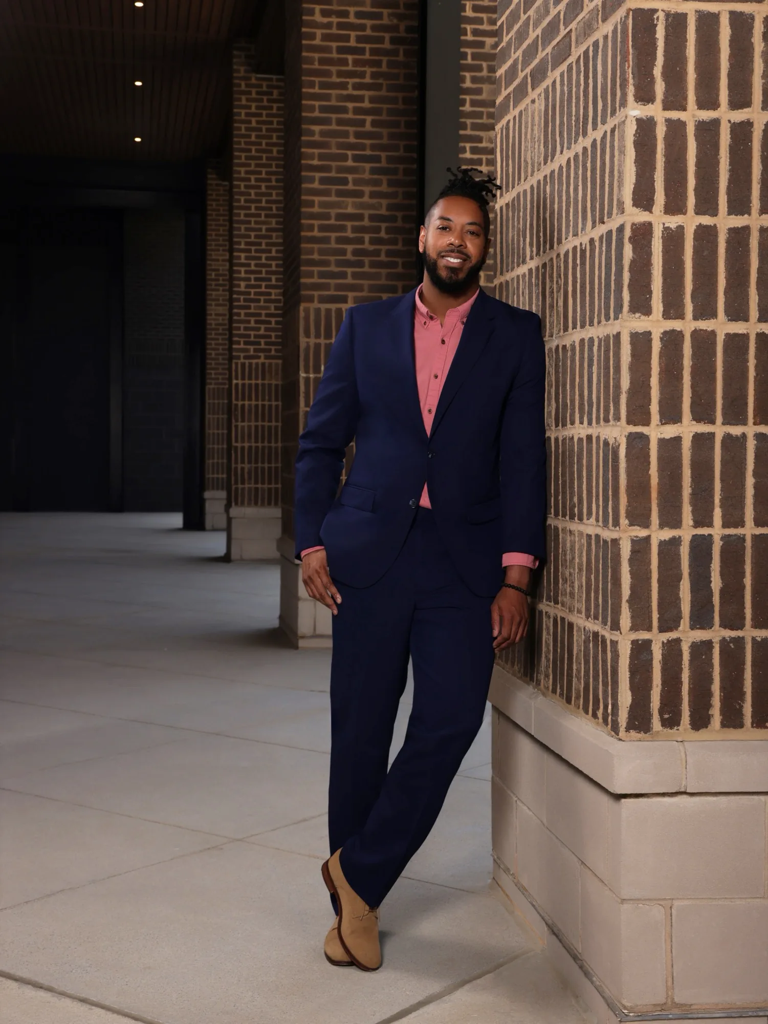 Full-length portrait of William in a navy suit and coral shirt