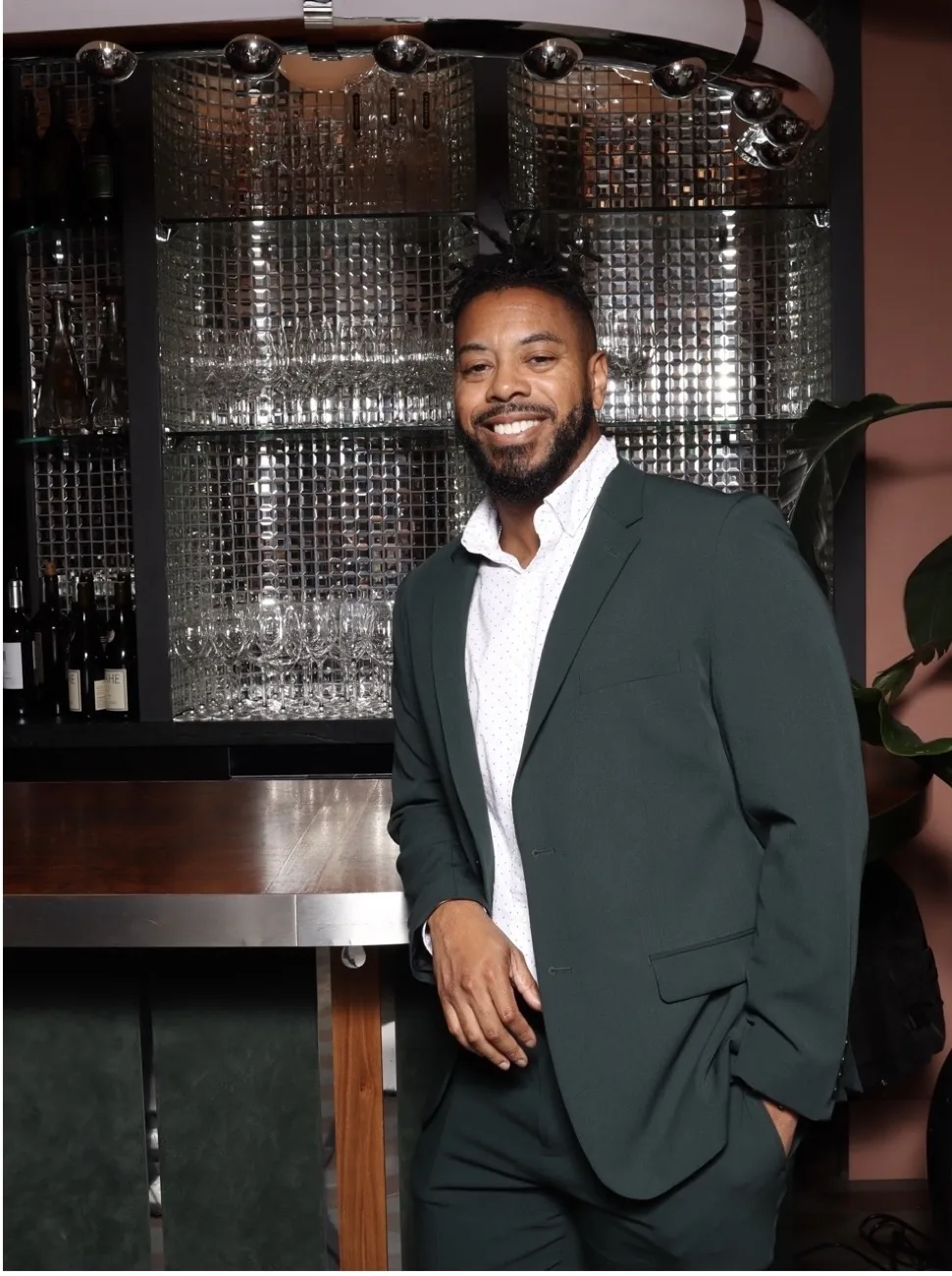 William wearing a green blazer in a restaurant setting